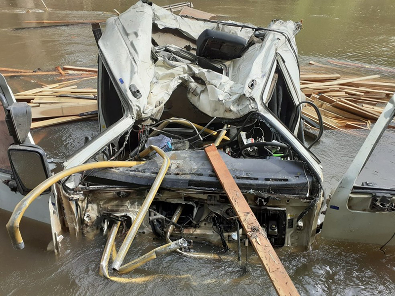 Caminhão carregado com madeira cai no Rio Peixe e deixa motorista ferido